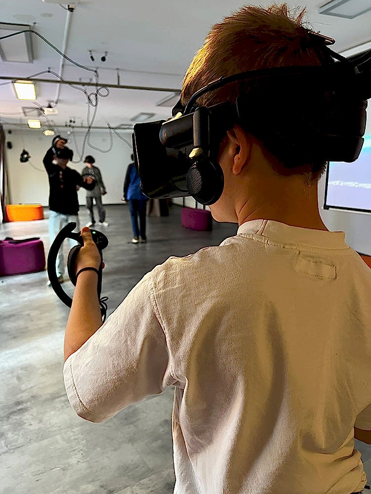 Schulkind einer Schulklasse mit VR Brille bei einem Klassenausflug